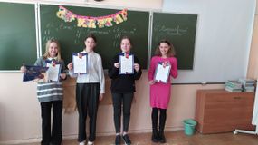 Четыре девочки с грамотами у школьной доски